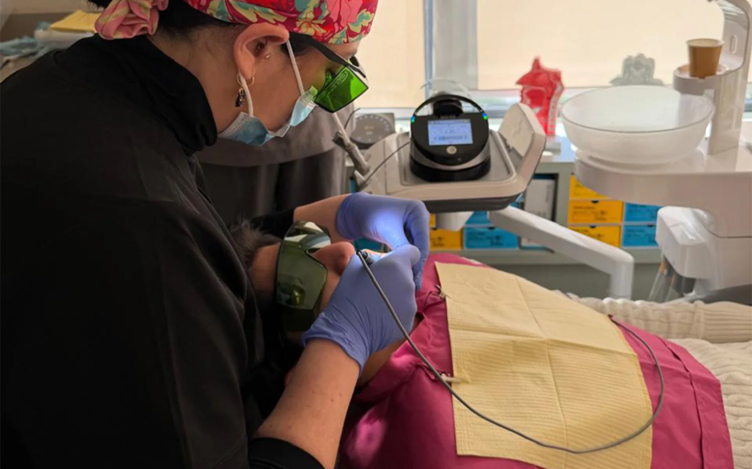 Tratamiento con láser dental en Haristoy Centro Odontológico, con lentes de protección para la especialista y la paciente